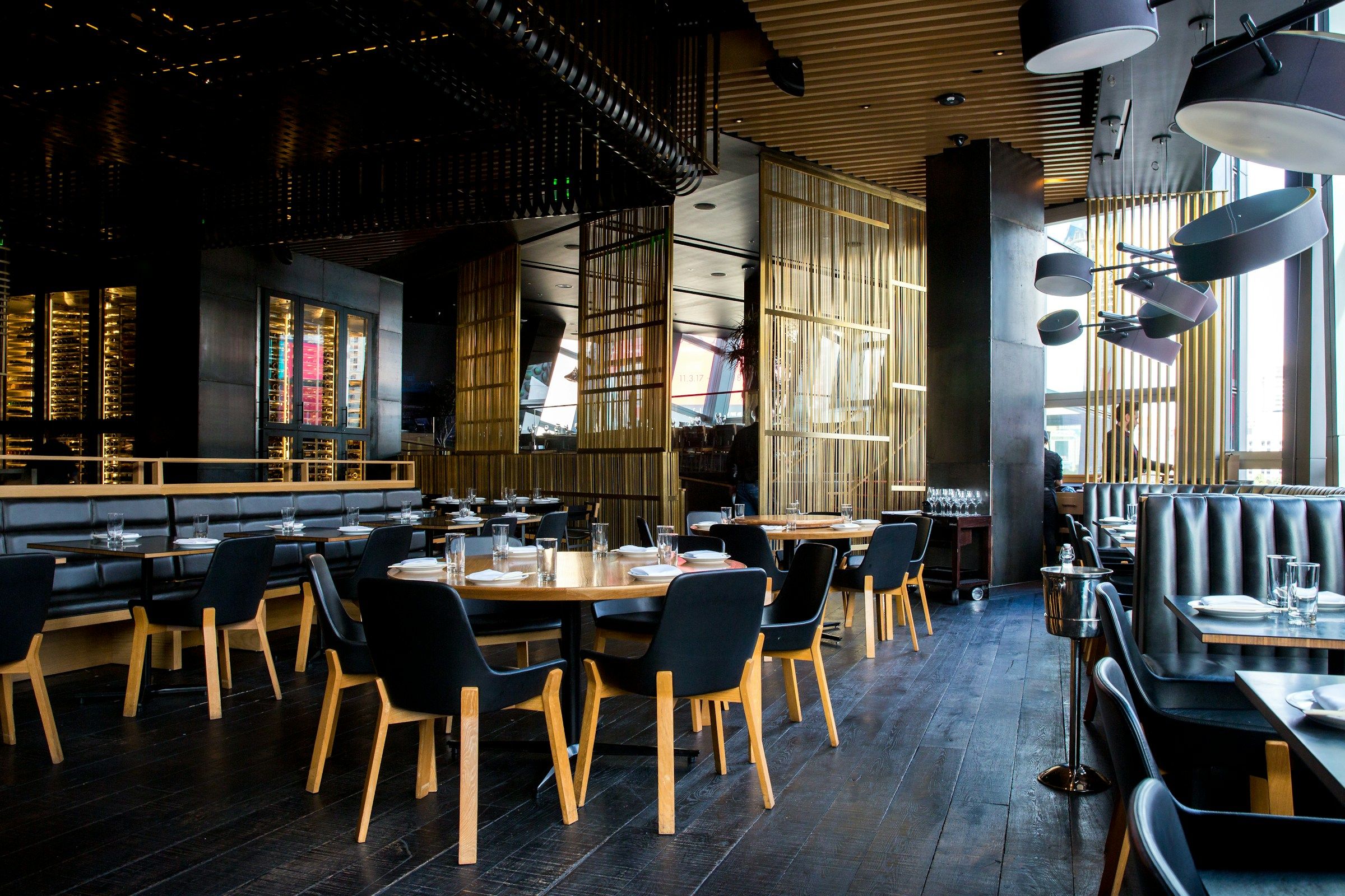 A restaurant dining floor with set tables and leather booth seating
