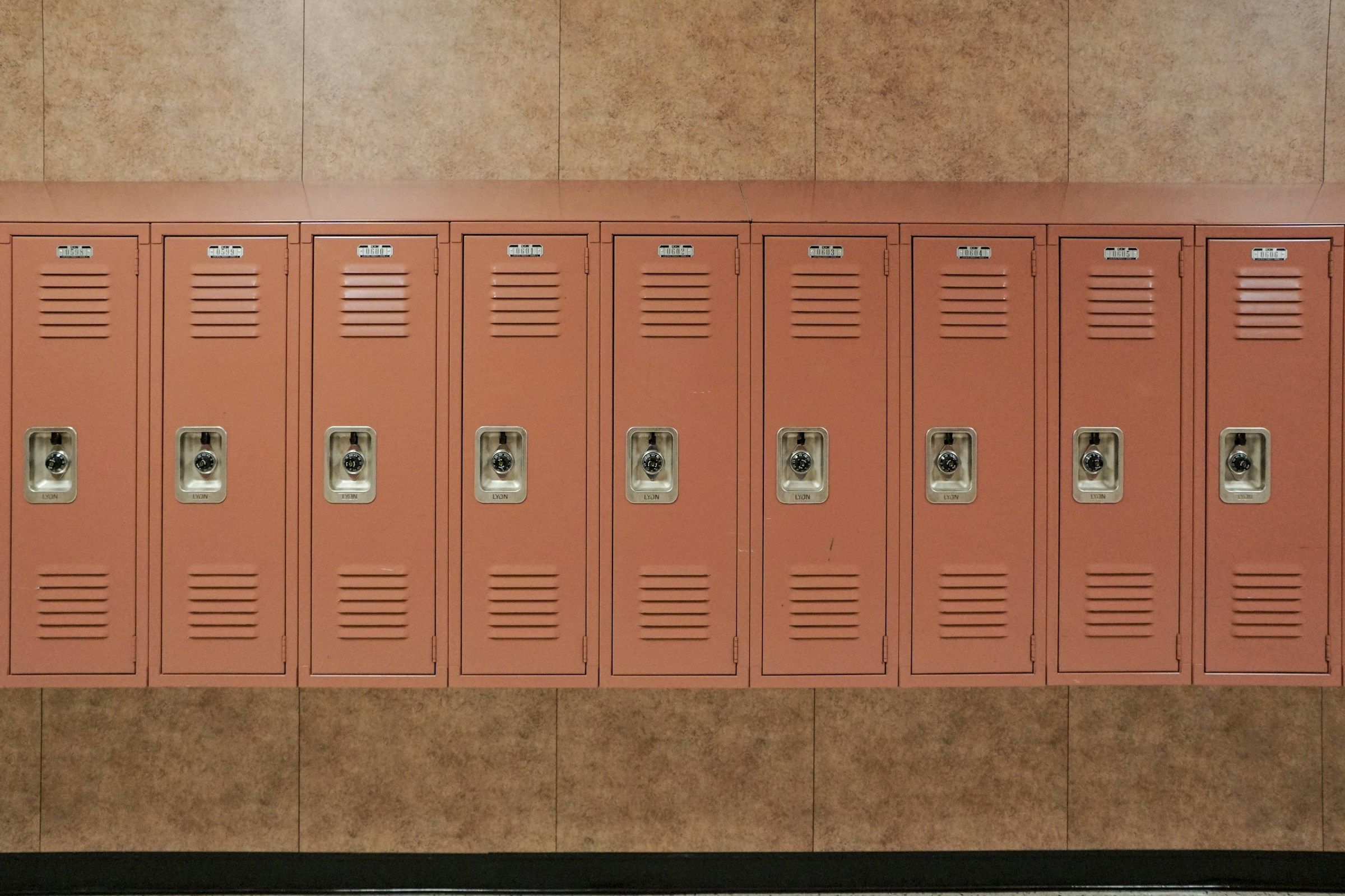 A row of salmon-colored hallway lockers in a school